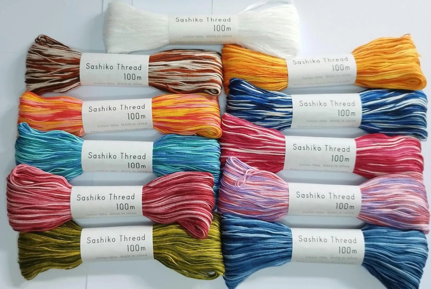 Assorted colors of Sashiko thread spools on a white background