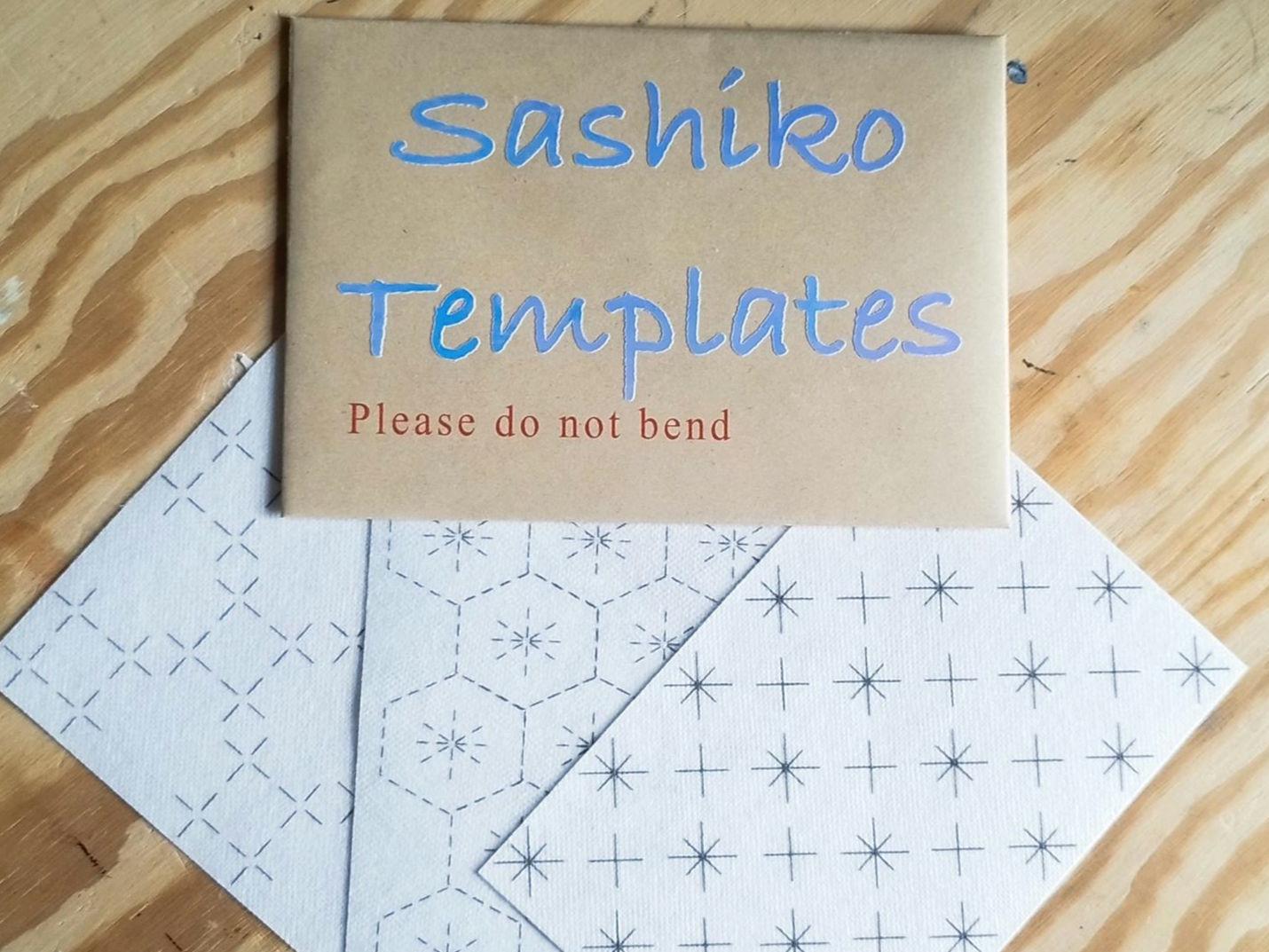 A hardbacked envelope labeled 'Sashiko Templates' containing washable sashiko transfers displayed on a wooden surface.