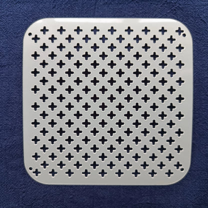 white square stencil of alternating crosses on a blue fabric background