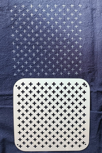 White square with black cross pattern on a blue textured background