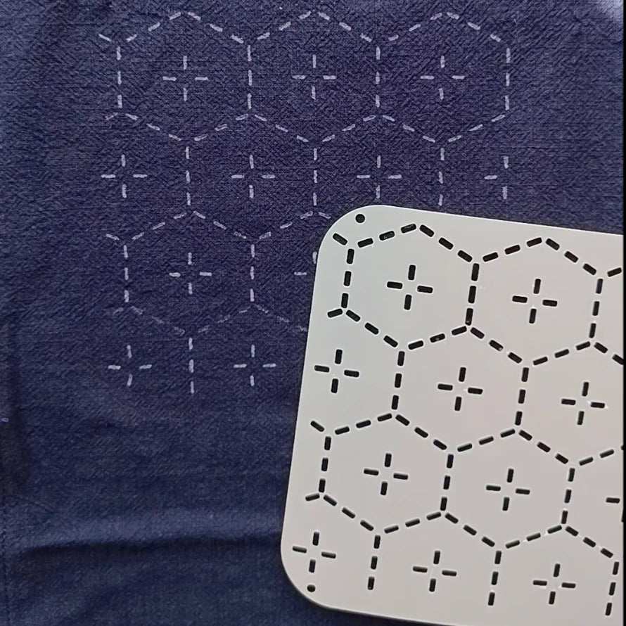 Hexagonal stitching pattern on a blue fabric and a white card with black stitching.
