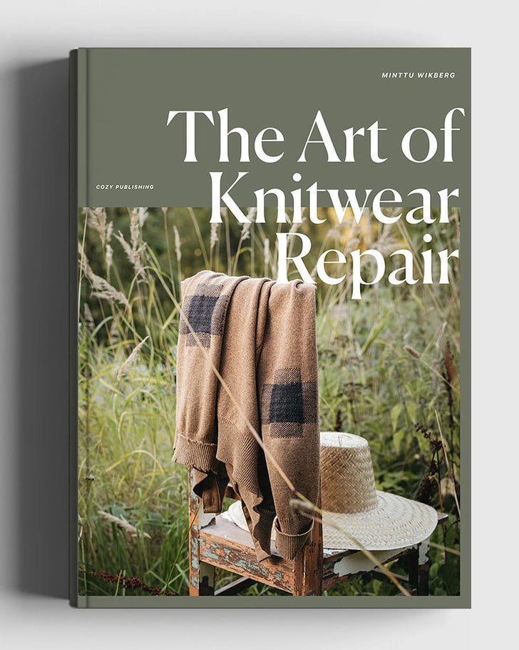 Book titled 'The Art of Knitwear Repair' with a cover featuring a chair and blanket in a natural setting.