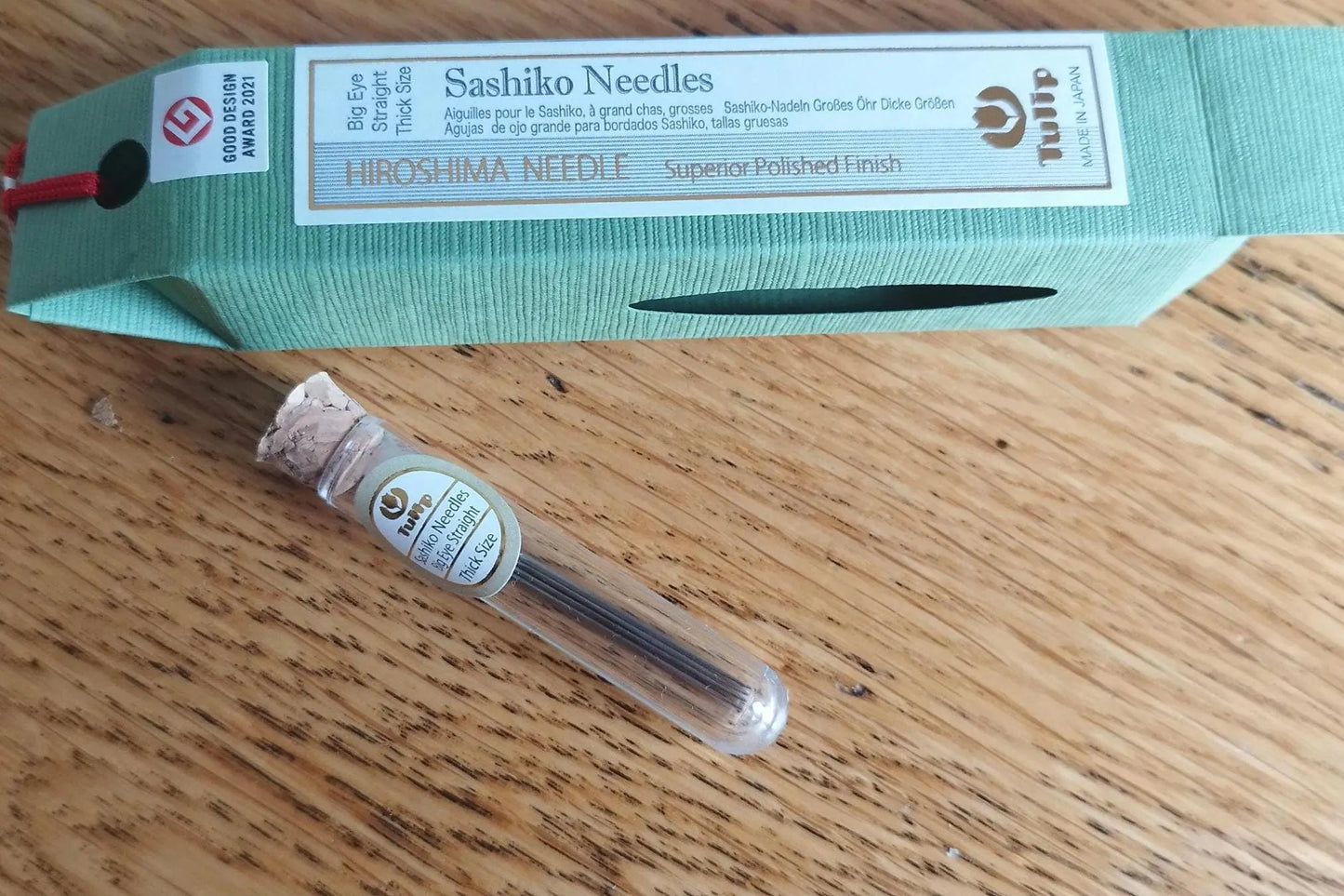 A package of Tulip Hiroshima sashiko needles with one needle displayed in front of the packaging, showing a thick needle with a large eye designed for embroidery.