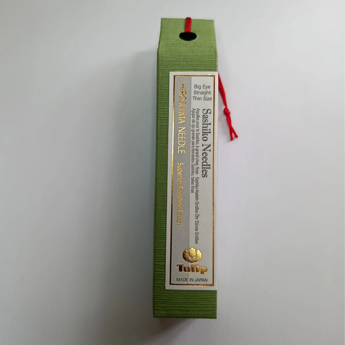 Sashiko needles packaging with green box and white label on a light gray background