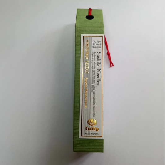 Sashiko needles packaging with green box and white label on a light gray background