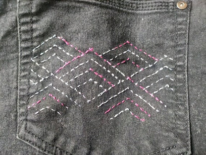 Pink and White Stitching of stacking pyramid sashiko design on the black denim pocket.