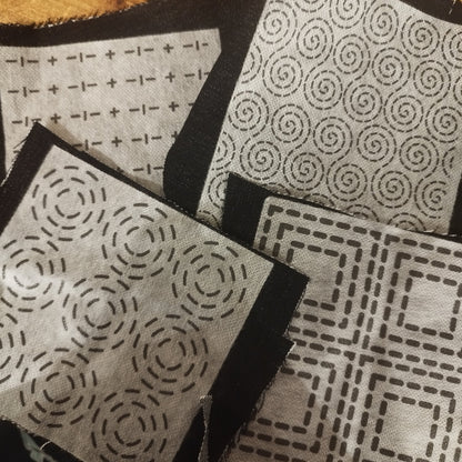 Sashiko transfers attached to fabric samples. Two square designs and two rectangular design patches