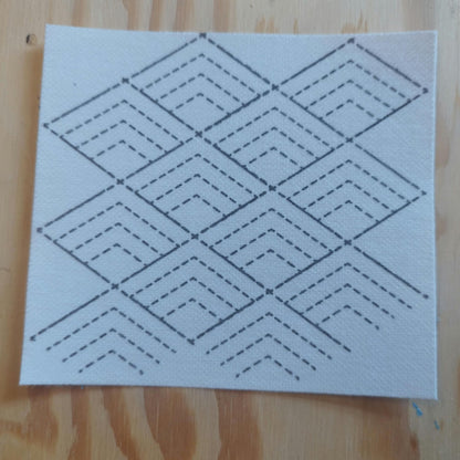 A square sashiko transfer design of stacking pyramids. The design is approx 2 pyramids wide, and 3 pyramids tall. The pyramid has 3 layers of dashed lines and a solid top line.